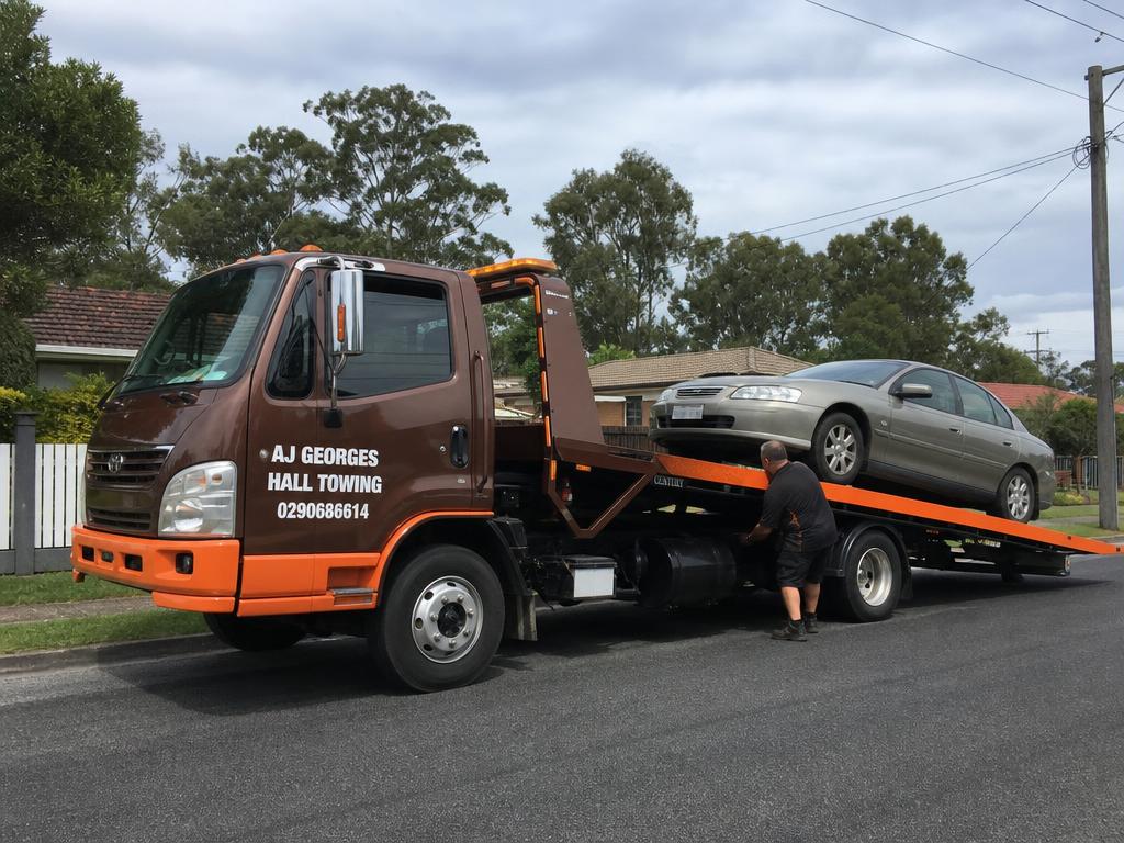 AJ Georges Hall Towing truck loading a car
